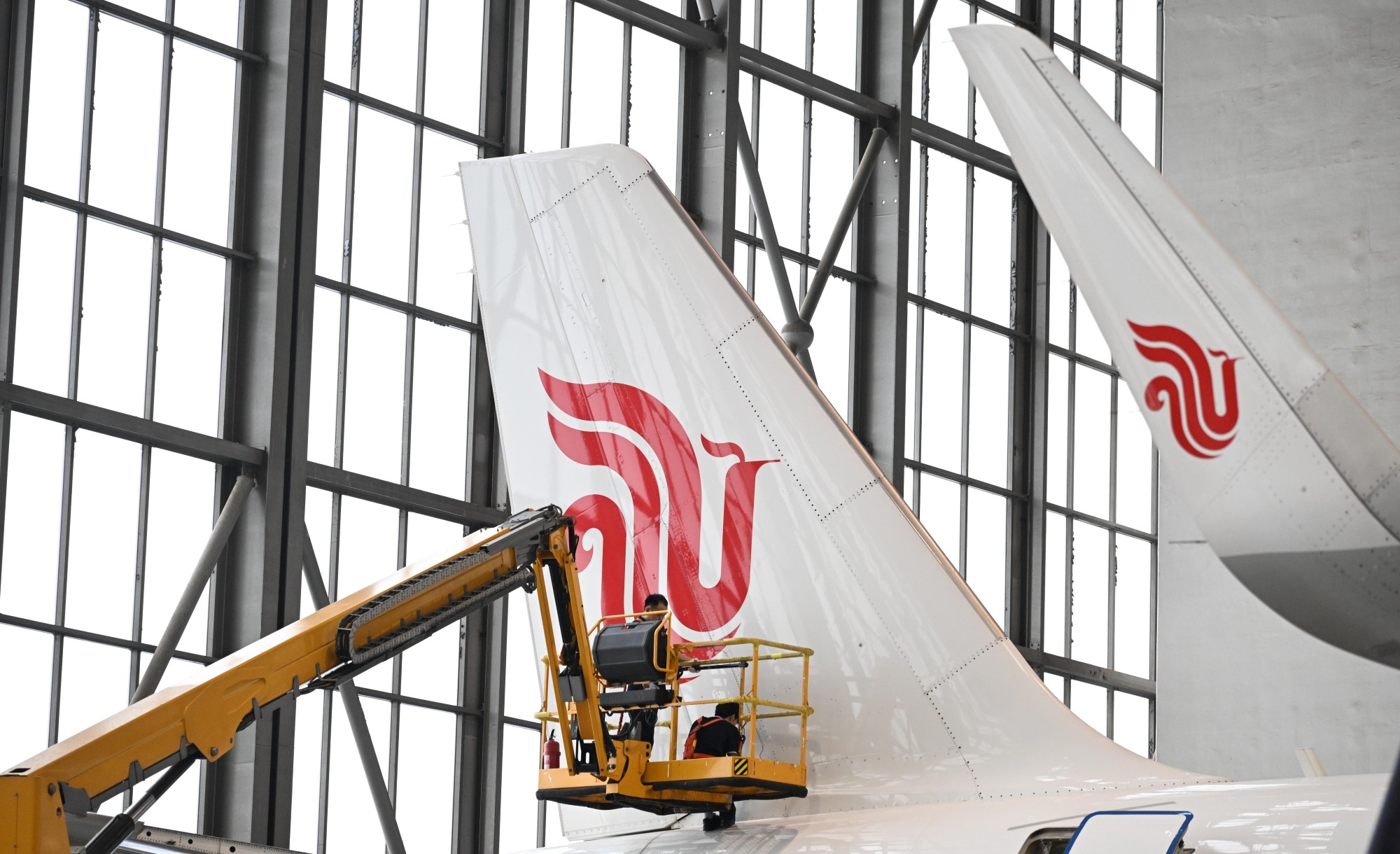 近日，中航集团开始执行2025—2026年冬春航季航班计划，运力投入同比增长16%。图为工程师在机库中对飞机尾翼进行维护。