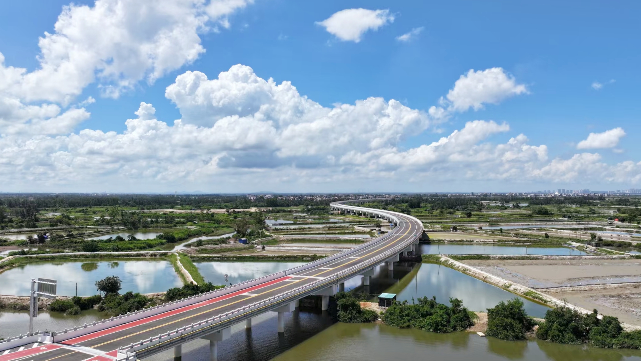 中铁二局承建的北门江特大桥是环新英湾支线的控制性工程，全长2074米，设计时速60公里。该桥位于海湾和红树林自然保护区内，项目部严格遵循“生态优先、绿色施工”理念，桥面采用防滑耐磨环保材料，实现施工废水、扬尘100%达标处理，确保工程建设与滨海生态和谐共生。