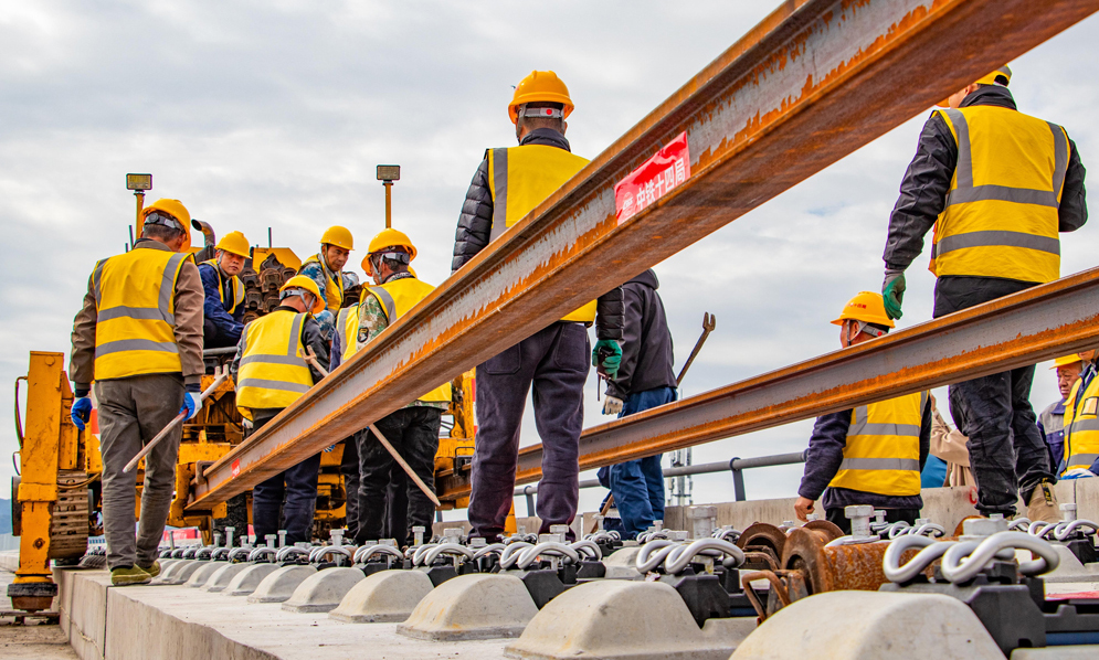 杭台高铁温玉段是一条集路网、城际、旅游及经济开发功能于一体的客运专线，主要承担城际客流。项目建成运营后将填补玉环市铁路空白，形成台州“县县通铁路、铁路网全覆盖”的交通新格局，对于加快打造浙江省1小时高铁交通圈、完善区域路网结构布局、促进沿线文旅产业融合发展等具有重要意义。图为施工人员在铺设长轨。