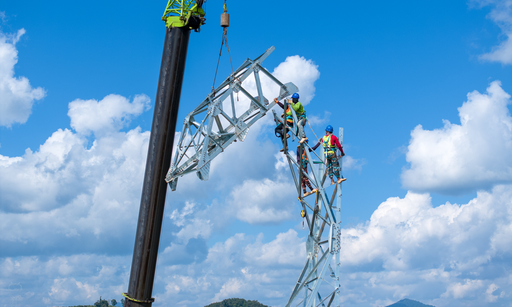 南方电网施工人员在吊车配合下组立铁塔。