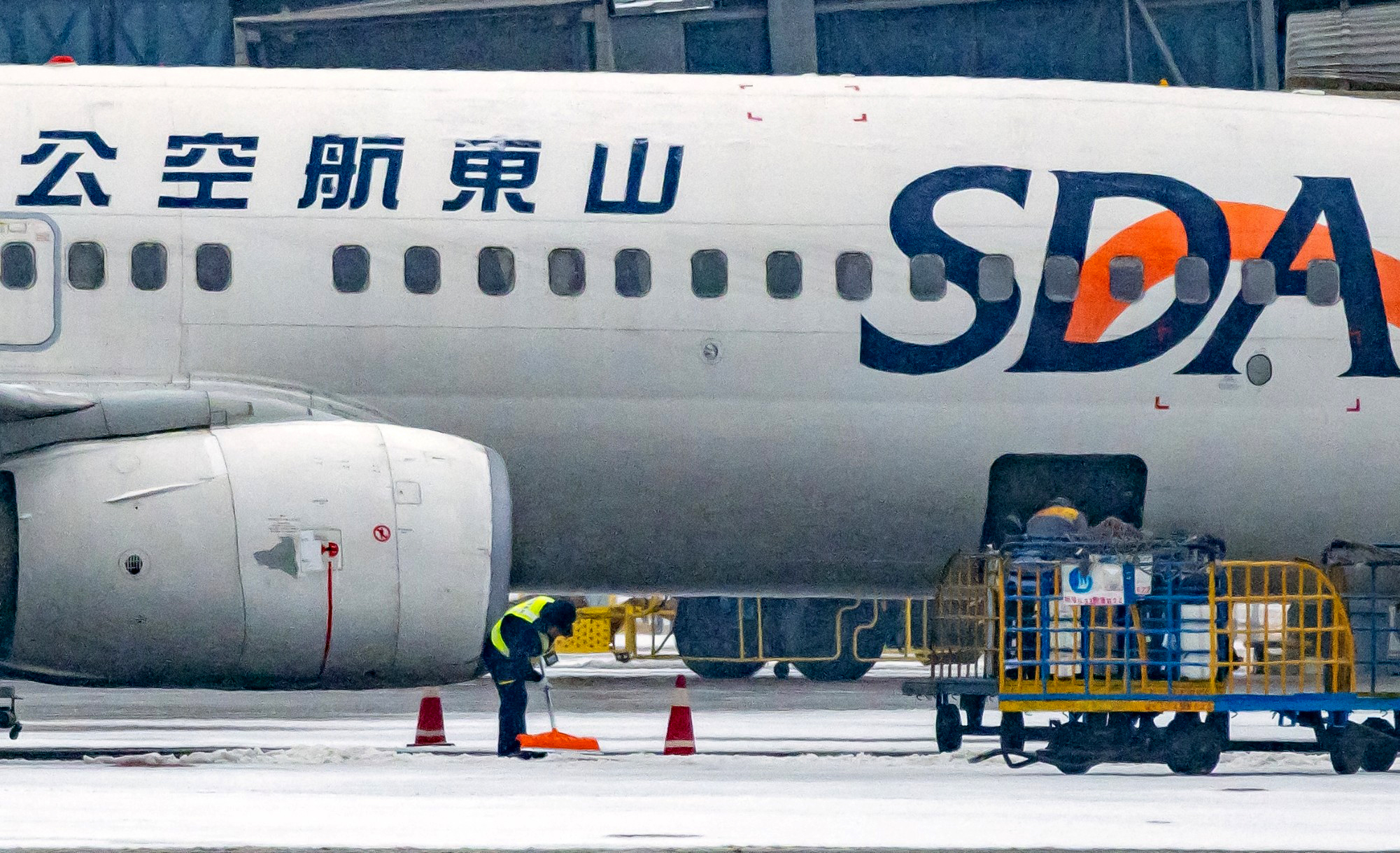 山东青岛机场，中航集团工作人员全力清除机坪积雪，保障航班进出港平稳运行。