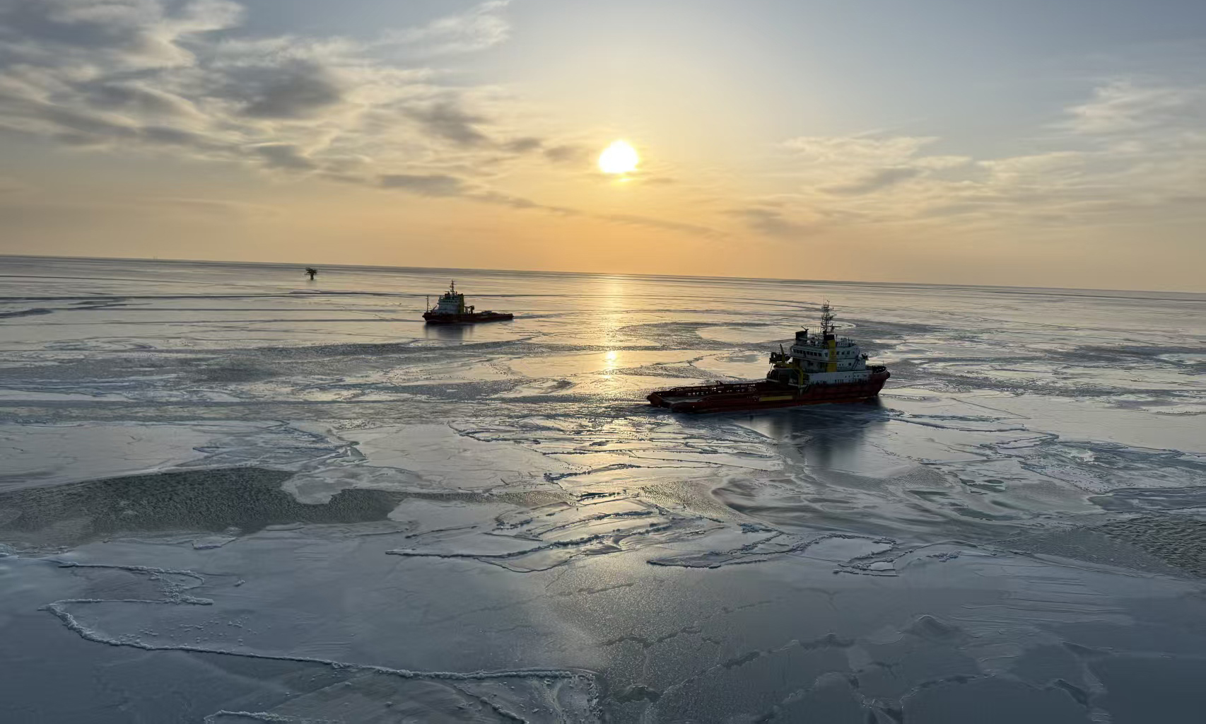 在科技防冰的基础上，锦州9-3油田同步落实传统防冰除冰措施，对生产系统进行全面“体检”，重点排查管线、阀门、仪表等关键部位防冻隐患，同时加强应急物资储备。针对稠油输送难题，油田采用“电伴热带+保温材料”双重保护措施，确保原油生产在严寒环境下“血脉畅通”。图为两艘船舶在油田外输平台上游一侧进行破冰作业。