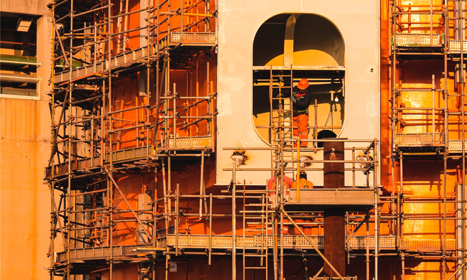 总装作业现场，工人在搭设脚手架。