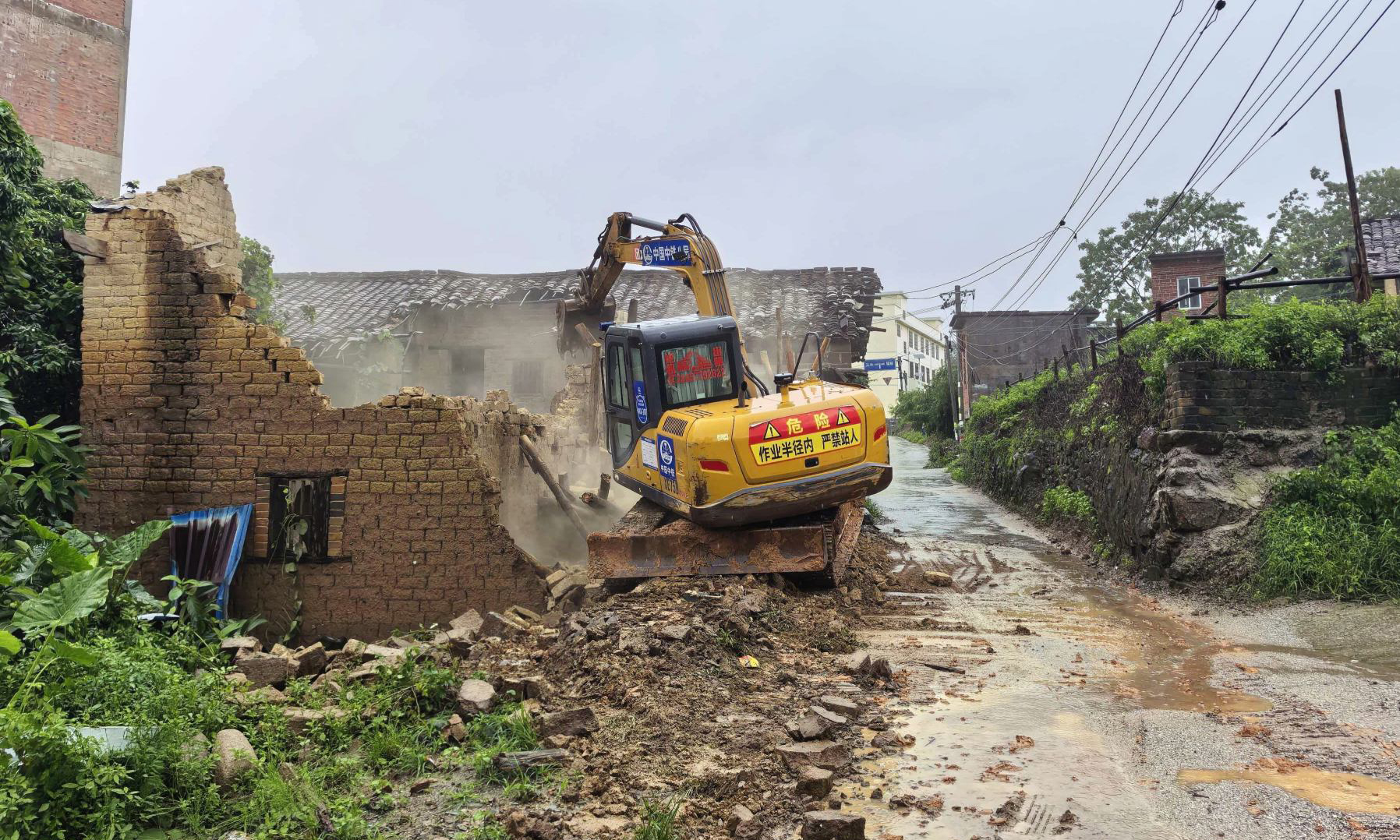 近日，受今年第10号台风“美莎克”影响，广西、广东等地出现强风暴雨天气。多地出现城乡内涝、道路中断及人员被困等多重险情。中国中铁旗下公司迅速集结力量投入抢险救援一线，全力保障人民群众生命财产安全。图为中铁八局玉浦高速公路项目部有序拆除广西浦北县老旧房屋，及时消除坍塌隐患。